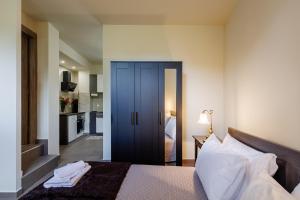 a bedroom with a bed with a blue door at Olive and Sea Suites in Kalamata