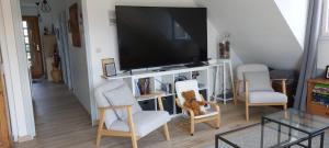 a living room with two chairs and a flat screen tv at Location vacances in Cucq