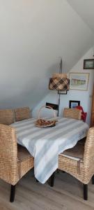 a table with wicker chairs and a blanket on it at Location vacances in Cucq