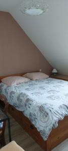 a bed with a blue and white blanket on it at Location vacances in Cucq