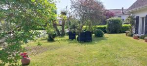 a yard with two chairs in the grass at Location vacances in Cucq +2 photos
