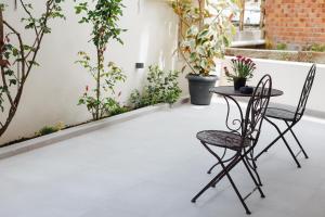 a table and chairs on a balcony with plants at Olive and Sea Suites in Kalamata