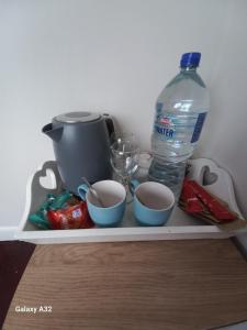 a shelf with a bottle of water and two cups at Fishing in Foxford +11 photos