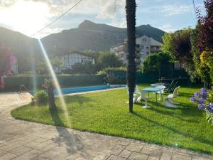a person standing in a yard with a table and chairs at La Choza in Oriñón