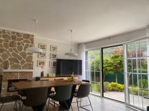 a dining room with a table and chairs and a television at La Choza in Oriñón