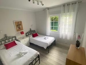a bedroom with two beds and a window at La Choza in Oriñón +45 photos