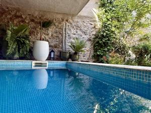a swimming pool with a vase sitting on top of it at L'oiseau Bleu FLAMANT in Roubia