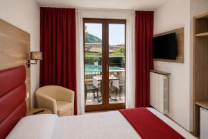 a hotel room with a bed and a view of a pool at VillaCuore in Tavernerio
