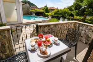 a table with bread and fruit on a balcony with a pool at VillaCuore in Tavernerio