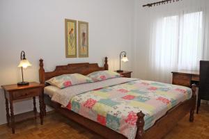 ein Schlafzimmer mit einem Bett mit zwei Nachttischen und zwei Lampen in der Unterkunft Apartments Romana in Postira