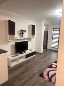 a living room with a flat screen tv on a white cabinet at D&D New Residence in Piteşti +9 photos