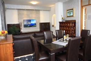 a dining room with a couch and a table and chairs at Apartments Romana in Postira