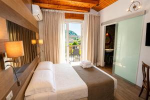 a bedroom with a large bed and a large window at VillaCuore in Tavernerio +16 photos