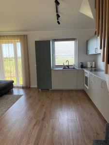 a kitchen with white cabinets and a hard wood floor at Tavo Jūros Namai in Palanga +12 photos