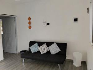 a black couch in a living room with pillows on it at Xamanai Playa Rincón III in Las Galeras