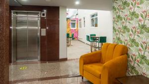 eine Lobby mit einem orangefarbenen Stuhl und einem Wartezimmer in der Unterkunft Hotel Menara in Mexiko-Stadt