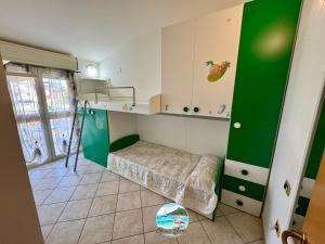 a small room with a bunk bed and green cabinets at Grace Home in Assemini