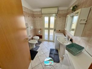 a bathroom with two toilets and a sink at Grace Home in Assemini +4 photos