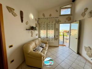 a living room with a couch and a sliding glass door at Grace Home in Assemini