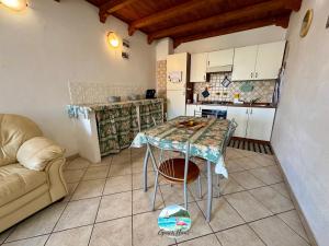 a small kitchen with a table and a couch at Grace Home in Assemini