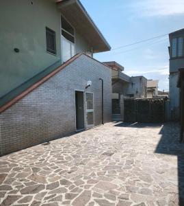 a brick building with a door and a stone courtyard at Camera matrimoniale - Villa Dalila in Silvi Paese