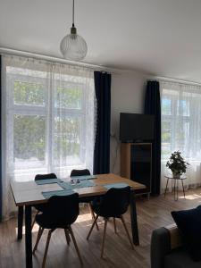a living room with a wooden table and chairs at Statek Osmička in Dolní Hořice