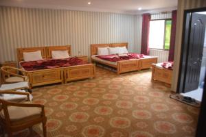 a room with two beds in a room at Pine Hills, Naran in Naran
