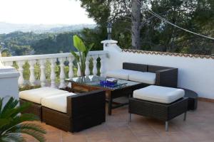 a patio with wicker chairs and a table at Traumhaftes Apartment mit Pool in Altea +15 photos
