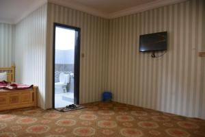a bedroom with a bed and a television on the wall at Pine Hills, Naran in Naran