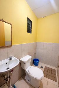 a bathroom with a white toilet and a sink at Balay in Butuan