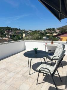 a patio with a table and chairs on a roof at Apartament Villa Luisa in Can Trabal
