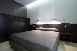 ボローニャにあるResidence i MasCa'のベッドルーム1室(ベッド1台、上部に2つの照明付)