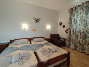 ein Schlafzimmer mit zwei Betten und einem Schmetterling an der Wand in der Unterkunft WHITE CASTLE Studios in Lefkos Karpathos