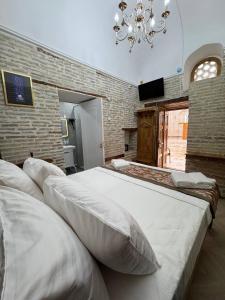 a bedroom with two beds and a chandelier at Turkman Madrasah XIX Century Hotel in Bukhara +20 photos