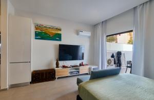 a bedroom with a bed and a tv in a room at Edificio Lux's - Apartamentos Tubarão in Santa Maria