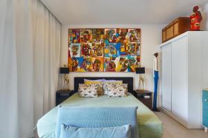 a bedroom with a bed with a painting on the wall at Edificio Lux's - Apartamentos Tubarão in Santa Maria +46 photos