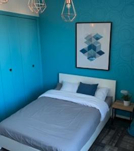 a blue bedroom with a bed with a blue wall at La Perpignanaise in Perpignan +9 photos