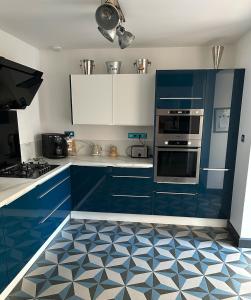 a kitchen with blue cabinets and a blue and white tile floor at La Perpignanaise in Perpignan