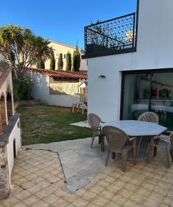 a patio with a table and chairs in a yard at La Perpignanaise in Perpignan