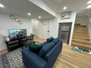 a living room with a blue couch and a television at Cosy and Cute Private Basement Suite in Winnipeg