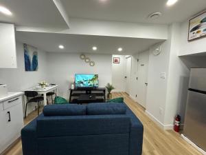 a living room with a blue couch and a kitchen at Cosy and Cute Private Basement Suite in Winnipeg