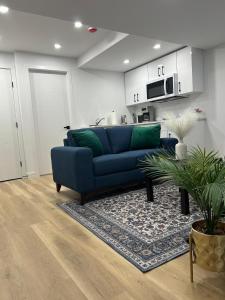 a living room with a blue couch and a rug at Cosy and Cute Private Basement Suite in Winnipeg +15 photos