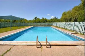 a large swimming pool with a white fence at Bras D'Or Lakes Campground in Baddeck Inlet