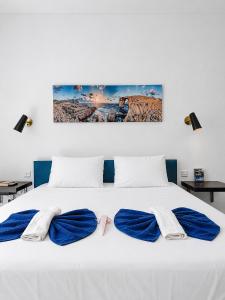 a white bed with two pairs of towels on it at Modern Duplex Apartment with Private Pool & AC Central Malta in Balzan
