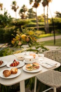 a white table with plates of food on it at Villa Favorita Hotel & Events in Marsala