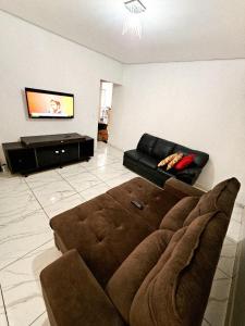 a living room with a couch and a flat screen tv at Chácara Recanto gramado in Tatuí
