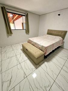 a bedroom with a bed and a chair and a window at Chácara Recanto gramado in Tatuí +19 photos