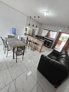 a living room and kitchen with a table and a couch at Chácara Recanto gramado in Tatuí