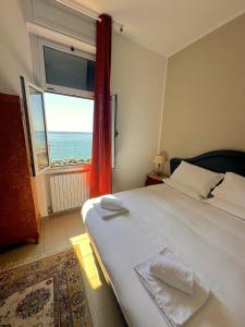 a bedroom with a bed with a view of the ocean at Villa Tergeste in Trieste