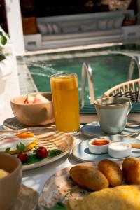 a table with plates of food and a glass of orange juice at Amarla Boutique Hotel Cartagena in Cartagena de Indias